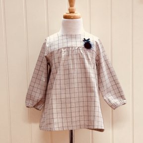 Floc checked dress in beige and blue. Full length mother-of-pearl fastening to the back and lovely pom-pom and bow embellishment to the front. Fully lined.