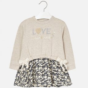 Mayoral mini beige and heart print long sleeved dress with a round neck for girls.  There is an elasticated waistband, the skirt is embellished with a multi coloured heart print. The top of the dress is also decorated with printing on the front and glitte