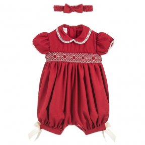 Pretty Originals red romper. Lace detail to sleeves and collar. Pretty hand-smocked detailing to the front and cream bows to both legs. Button up fastening to the back with built in belt. Elasticated back to legs with button fastening between legs.