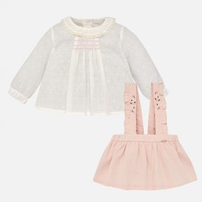 Mayoral baby girls 2 piece set.The Ivory blouse is long sleeved with smocking and a ruffled round neck collar. There are buttons to the  back. The pink skirt has straps  with embroidered flower detail and hidden buttons. There is an adjustable elasticated