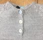Floc soft grey knitted long sleeved baby grow. Embellished with cute giraffe motif and mother-of-pearl buttons.  